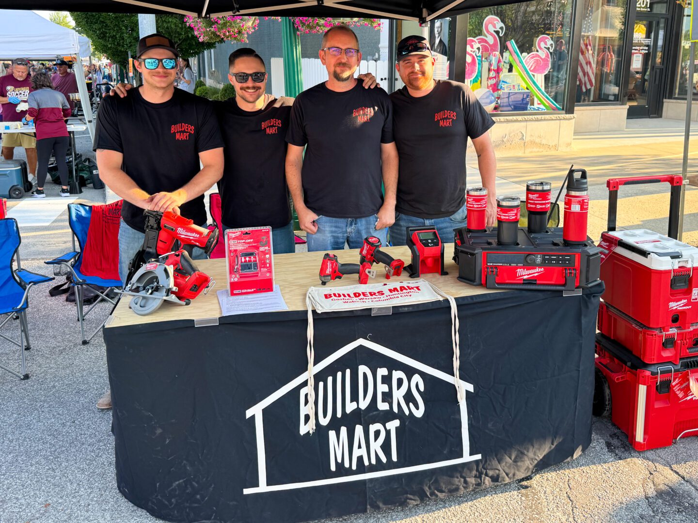 Pictured are four members of the Morsches Builders Mart Team posing for a photo behind their booth at First Fridays WrestleFest